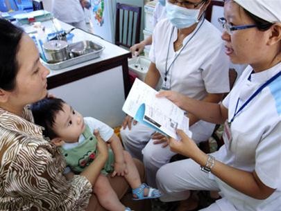 A woman takes her son to have vaccination in Ho Chi Minh City